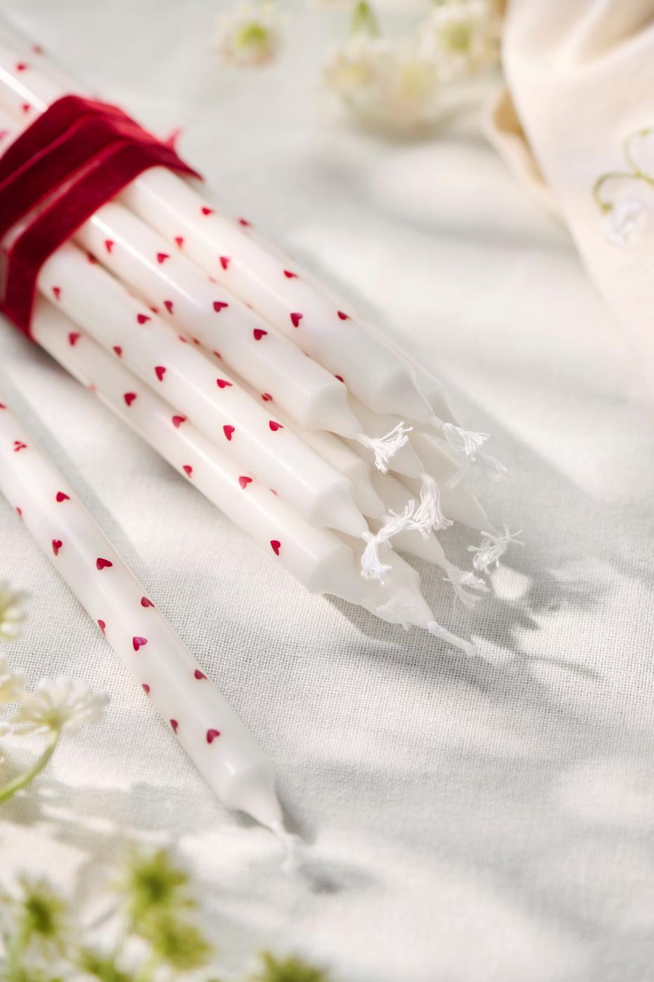 Dünne hohe Kerze mit roten Herzen