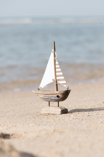 Schiff mit weissem und gestreiftem Segel und blauem Rumpf Nautico