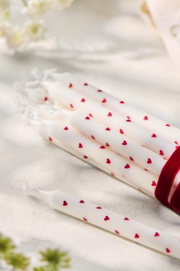 Dünne hohe Kerze mit roten Herzen